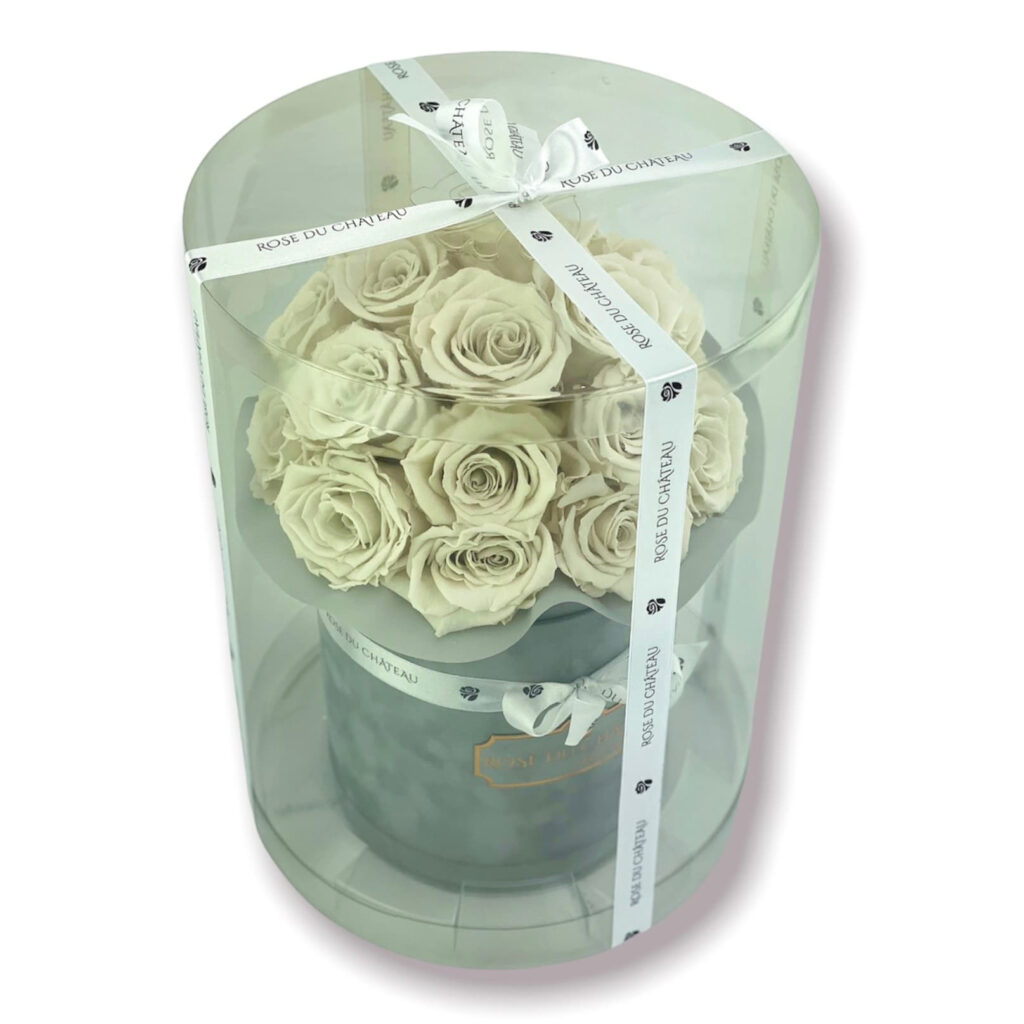 Piwonie wieczne, czy naprawdę kwitną przez 2 lata? sposób pakowania flowerboxa bouquet w plastikową tubę i przewiązanego wstążką logowaną Rose du Chateau, widok nieco z góry